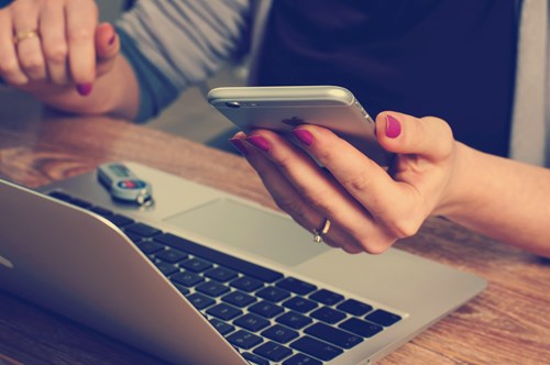 Person with computer and phone